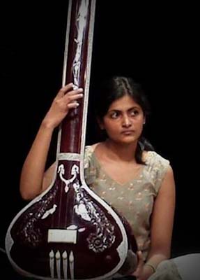 Woman playing the tanpura on stage